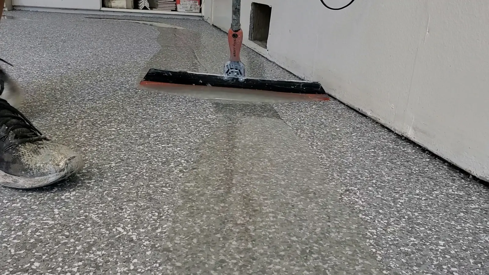 Topcoat being squeegeed onto a flake floor